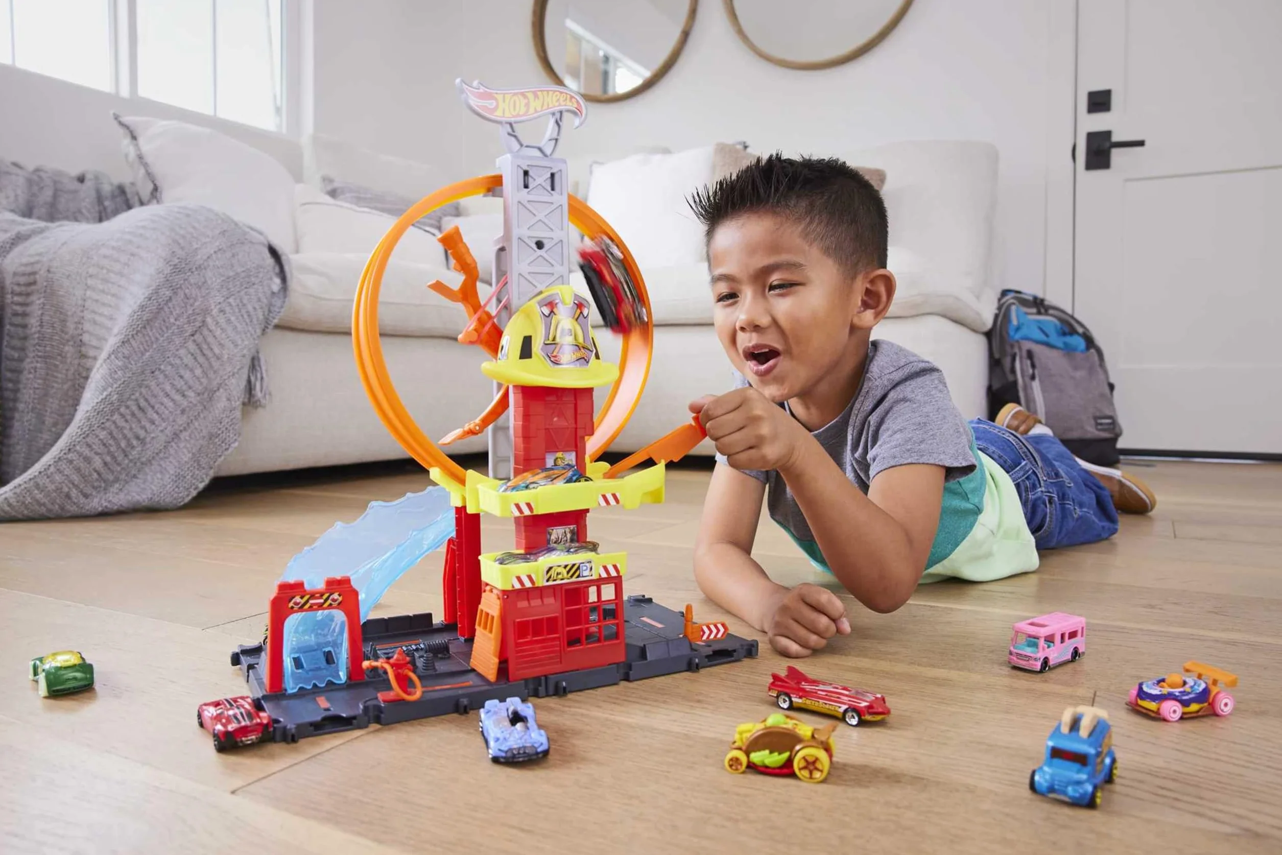 Hot Wheels HKX41 - HW City z 1 samochodem zabawkowym, ręcznie sterowaną windą, rampą przypominającą wodę, elementami toru, remizą strażacką z super pętlą, samochody zabawkowe dla dzieci od 4 lat